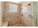 Luxurious bathroom featuring dual showerheads and stylish marble tile and glass block window at 7520 Captains Harbor Dr, Las Vegas, NV 89117