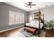 Bedroom featuring a four poster bed, plantation shutters, and wood floors at 7520 Captains Harbor Dr, Las Vegas, NV 89117