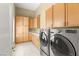 Spacious laundry room with ample cabinet space, tiled floor and modern washer and dryer at 7520 Captains Harbor Dr, Las Vegas, NV 89117