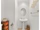 Stylish powder room with a pedestal sink, decorative mirror, and toilet at 7520 Captains Harbor Dr, Las Vegas, NV 89117