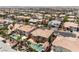 An aerial view shows a backyard pool oasis, surrounded by mature palm trees, in a sunny residential neighborhood at 7526 Gossamer Wind St, Las Vegas, NV 89139