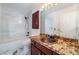 Well-lit bathroom showcasing a modern vanity, tub, and shower combo with marble tile at 7526 Gossamer Wind St, Las Vegas, NV 89139