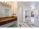 Bathroom vanity with marble countertop, wood cabinets, and views to the bright modern bathroom at 7526 Gossamer Wind St, Las Vegas, NV 89139