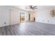 Large bedroom with gray wood floors, neutral walls, fan and access to a balcony at 7526 Gossamer Wind St, Las Vegas, NV 89139