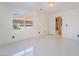 Bright bedroom with white tile flooring, window, and ensuite bathroom at 7526 Gossamer Wind St, Las Vegas, NV 89139