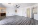 Large bedroom with gray wood floors, neutral walls, fan and access to ensuite bathroom at 7526 Gossamer Wind St, Las Vegas, NV 89139