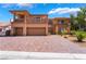 Stunning two-story home featuring a brick driveway, balconies, and a three-car garage at 7526 Gossamer Wind St, Las Vegas, NV 89139