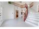 Bright foyer with a curved staircase, white tile flooring, and an elegant chandelier at 7526 Gossamer Wind St, Las Vegas, NV 89139