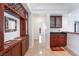 Hallway with dark wood cabinets, tile floors, and partial wet bar at 7526 Gossamer Wind St, Las Vegas, NV 89139
