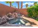 This backyard features a rock waterfall flowing into a custom hot tub surrounded by lush, tropical landscaping at 7526 Gossamer Wind St, Las Vegas, NV 89139