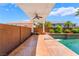 Covered patio with ceiling fan overlooking a stunning pool, perfect for outdoor relaxation and entertaining guests at 7526 Gossamer Wind St, Las Vegas, NV 89139