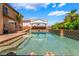 Relax in this spacious pool featuring elegant tile work, a covered patio, and ample space for outdoor enjoyment at 7526 Gossamer Wind St, Las Vegas, NV 89139