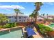 Aerial shot of the backyard pool with a spa, blue umbrella, and lush green landscaping at 7526 Gossamer Wind St, Las Vegas, NV 89139