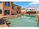 A sprawling backyard pool with built in seating, covered patio, and multiple access stairs at 7526 Gossamer Wind St, Las Vegas, NV 89139