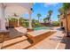 Outdoor pool with a covered patio, ceiling fan, and manicured palm trees for a resort style experience at home at 7526 Gossamer Wind St, Las Vegas, NV 89139