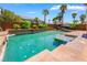 This large backyard pool features a tanning shelf, covered patio, and tropical landscaping for ultimate relaxation at 7526 Gossamer Wind St, Las Vegas, NV 89139