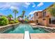 Backyard oasis with a sparkling pool, palm trees, diving board, and a spacious patio area at 7526 Gossamer Wind St, Las Vegas, NV 89139