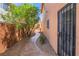 Landscaped walkway leading to a charming home entrance and secured by an ornate security door at 7526 Gossamer Wind St, Las Vegas, NV 89139