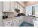Well-lit kitchen with white cabinets, tile countertops, and modern appliances at 7815 Windward Rd, Las Vegas, NV 89147