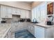 Traditional kitchen featuring tile countertops, updated appliances, and a large window with natural light at 7815 Windward Rd, Las Vegas, NV 89147