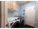 Laundry room features a GE washer and dryer with cabinet storage above at 7815 Windward Rd, Las Vegas, NV 89147
