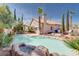 Backyard pool with a waterfall, palm trees, and desert landscaping at 7815 Windward Rd, Las Vegas, NV 89147