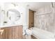 Updated bathroom featuring modern fixtures, wood vanity, and shower-tub combo with gray tiles at 7932 Diamond Rock Way # 101, Las Vegas, NV 89128