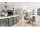 Bright, open kitchen featuring a green island with seating and an adjacent dining area at 7932 Diamond Rock Way # 101, Las Vegas, NV 89128