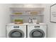 Bright laundry room featuring modern washer/dryer, ample shelving, and stylish decor at 7932 Diamond Rock Way # 101, Las Vegas, NV 89128