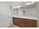 Spacious bathroom featuring dual sinks, wood cabinets, a large mirror, and clean modern lines at 8016 Carpenter Creek Ave, Las Vegas, NV 89113