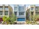 Contemporary home with a blue garage door, professionally landscaped front yard, and modern architectural details at 8016 Carpenter Creek Ave, Las Vegas, NV 89113