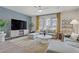 Relax in this living room featuring modern decor, stylish furniture, and large windows with natural light at 8016 Carpenter Creek Ave, Las Vegas, NV 89113