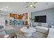 Open-concept living room and kitchen featuring hardwood floors, stainless steel appliances, and breakfast bar seating at 8016 Carpenter Creek Ave, Las Vegas, NV 89113
