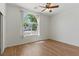 This bedroom features a ceiling fan, an arched window, and neutral decor at 8114 Lapis Harbor Ave, Las Vegas, NV 89117