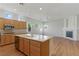 Open-concept kitchen with a center island, wooden cabinets, stainless steel appliances, and a view of the living area at 8114 Lapis Harbor Ave, Las Vegas, NV 89117