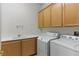Well-equipped laundry room with washer, dryer, and storage cabinets at 8114 Lapis Harbor Ave, Las Vegas, NV 89117