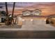 Stunning home with a three-car garage and a beautiful desert landscape during sunset at 8140 Bay Harbor Dr, Las Vegas, NV 89128