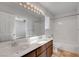 Bright bathroom featuring a double vanity, large mirror with decorative lighting, and a tiled shower-tub combo at 8236 Bermuda Beach Dr, Las Vegas, NV 89128