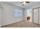 This bedroom features neutral carpet, a ceiling fan, and a door to the attached bathroom at 8236 Bermuda Beach Dr, Las Vegas, NV 89128