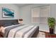Staged bedroom featuring a gray bed frame with a decorative plant and large window at 8236 Bermuda Beach Dr, Las Vegas, NV 89128