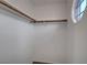Empty walk-in closet with shelf and wooden clothing rods at 8236 Bermuda Beach Dr, Las Vegas, NV 89128