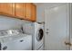 Functional laundry room with white washer and dryer, cabinets for storage, and a door to the exterior at 8236 Bermuda Beach Dr, Las Vegas, NV 89128