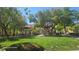 Expansive community park featuring lush green lawns, mature trees, and shaded seating areas for relaxation and recreation at 8928 Hand Painted Ct, Las Vegas, NV 89149