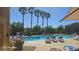 Sparkling swimming pool surrounded by lounge chairs and swaying palm trees, creating a resort-like community amenity at 8928 Hand Painted Ct, Las Vegas, NV 89149