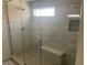 Sleek glass shower with marble look tile and a built-in bench at 9232 Marlia St, Las Vegas, NV 89123
