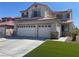 Inviting two-story home featuring a 3-car garage, desert landscaping, and a charming balcony at 9232 Marlia St, Las Vegas, NV 89123