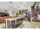 Open concept kitchen with stainless steel appliances and a granite topped island at 961 Cutter St, Henderson, NV 89011