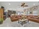 Inviting living room open to the kitchen featuring tile floors, a ceiling fan, and large leather seating at 961 Cutter St, Henderson, NV 89011