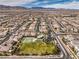 A community aerial view featuring a tennis court and green space among tidy residential streets and homes at 9655 Shadow Cliff Ave, Las Vegas, NV 89166