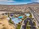 Birds eye view of a community, featuring a pool, park, and homes, surrounded by roads and desert landscape at 9655 Shadow Cliff Ave, Las Vegas, NV 89166